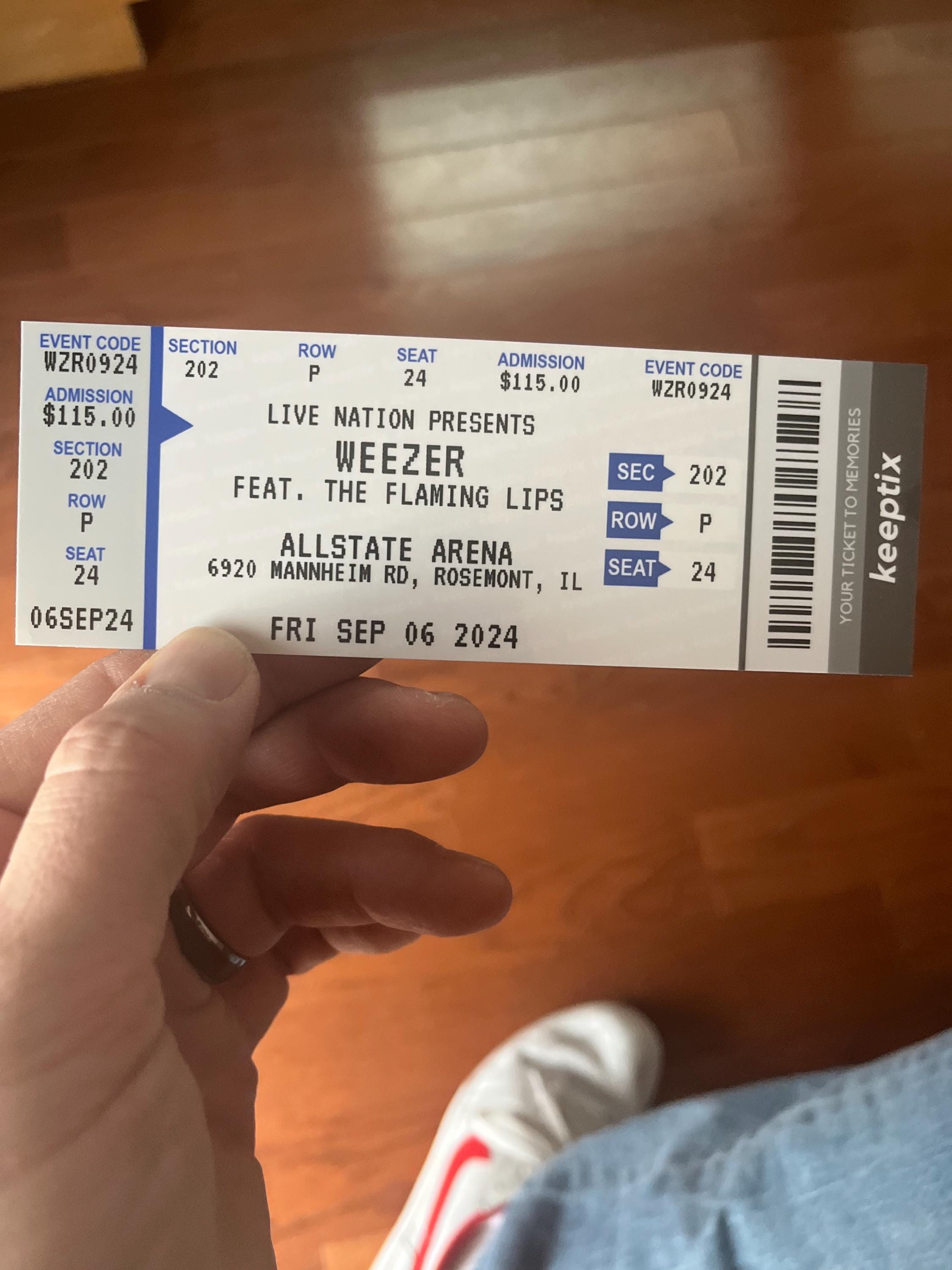 A blue custom KeepTix ticket held in one hand